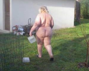 Dikke boerin voedert de kippen in haar nakie